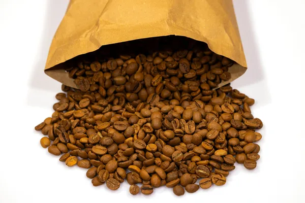 Roasted coffee beans spilling from an open brown paper bag